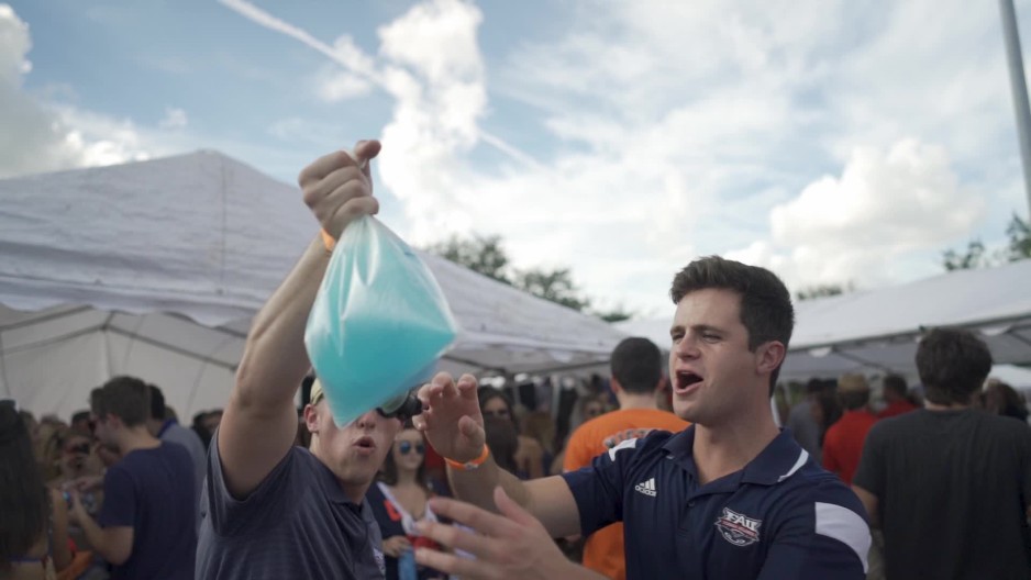 Static shot of young man slapping the bag at tailgate ClipStock
