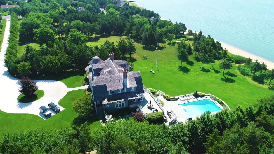 Luxurious mansion with a pool and long stone driveway on the coast of