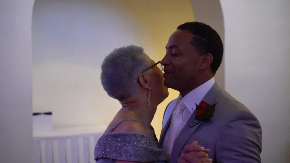 black groom dancing with his mother at wedding reception in ballroom