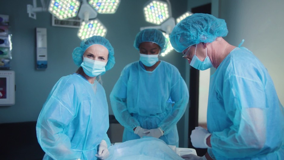 Surgeons cover deceased patient with sheet and shakes head ClipStock