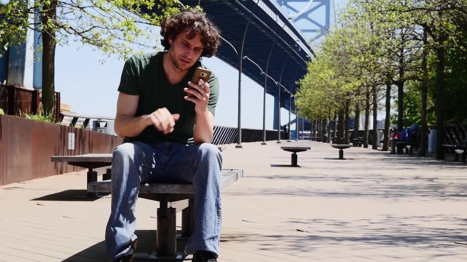 Tilt up of man upset with text message | ClipStock