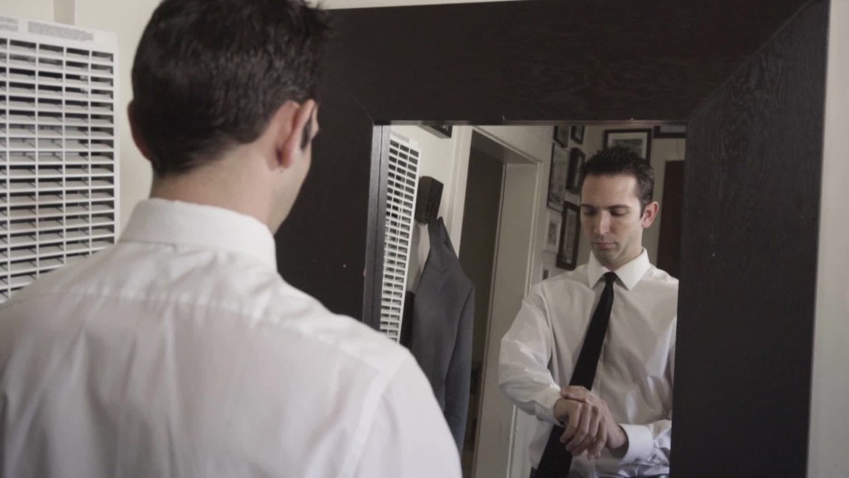 Business man putting on watch while getting ready for work | ClipStock