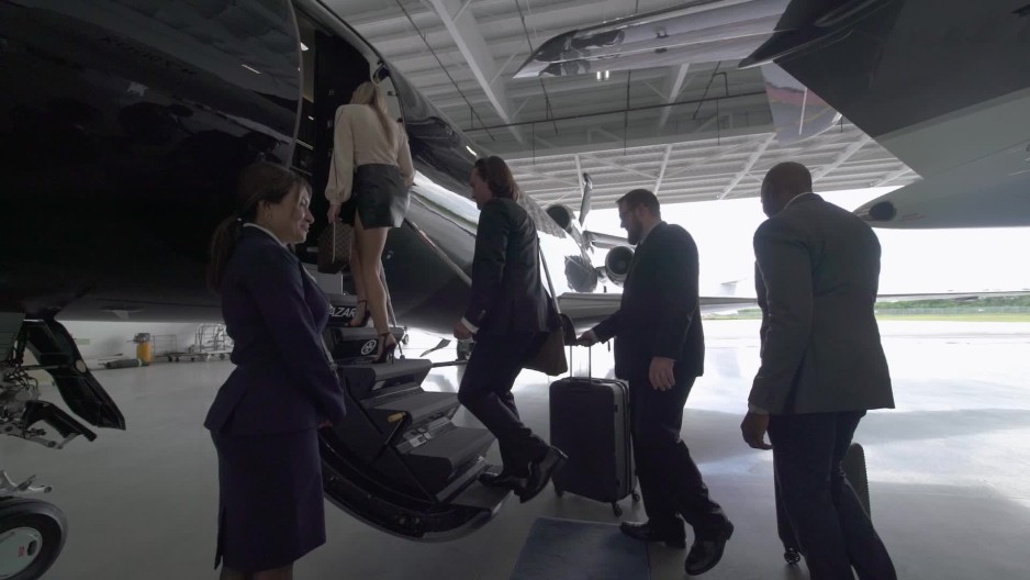 young professionals walking in flight hangar boarding a private jet in a flight hangar | ClipStock