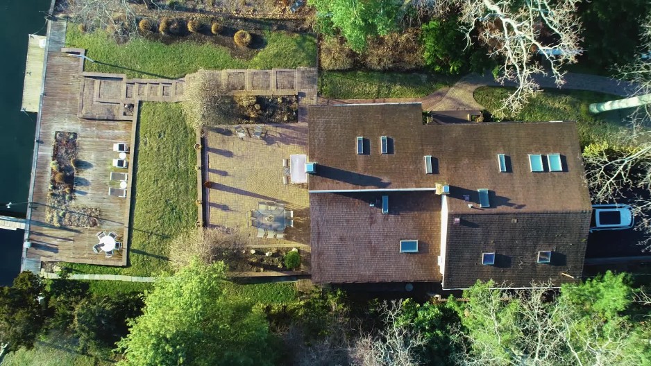 Upper class waterfront home with wooden deck and boat dock in