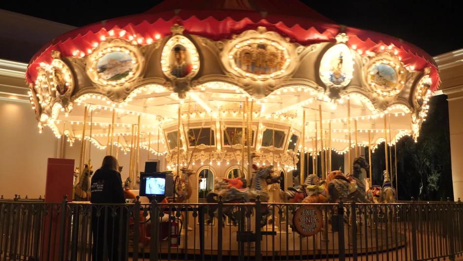 Wide shot of bright spinning carousel | ClipStock