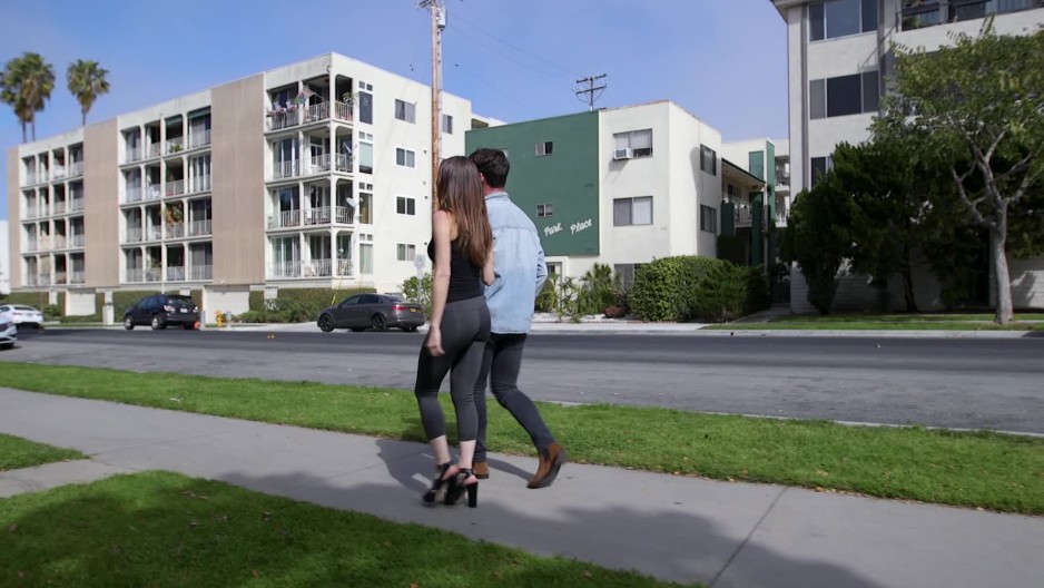 Man and woman couple walking together down sidewalk Slow Motion