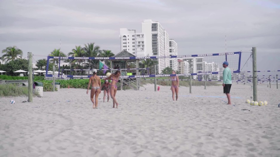Action shot of beach volleyball players bumping ball slow motion