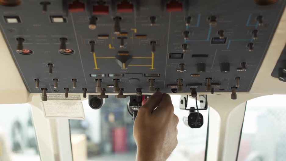 Pilots flipping switches on panel in cockpit of plane ClipStock