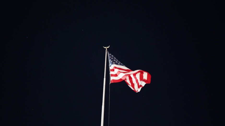 Wide shot of American flag waving in night sky ClipStock