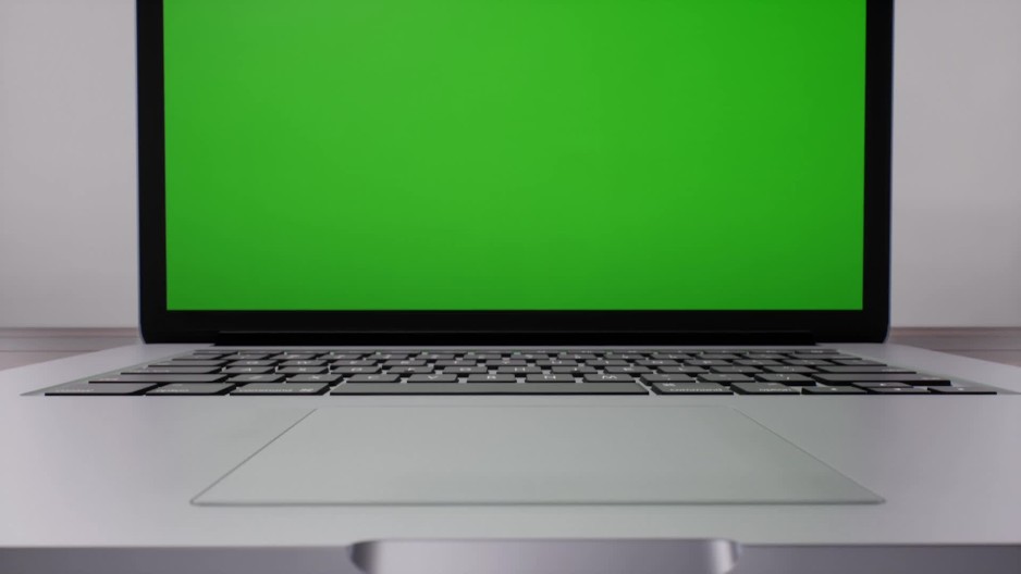 Tilt up towards laptop computer displaying green screen Slow Motion ClipStock