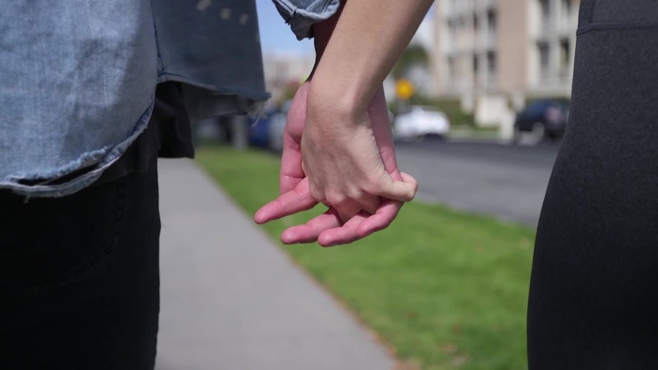 Boyfriend girlfriend couple walking holding hands on sidewalk | ClipStock