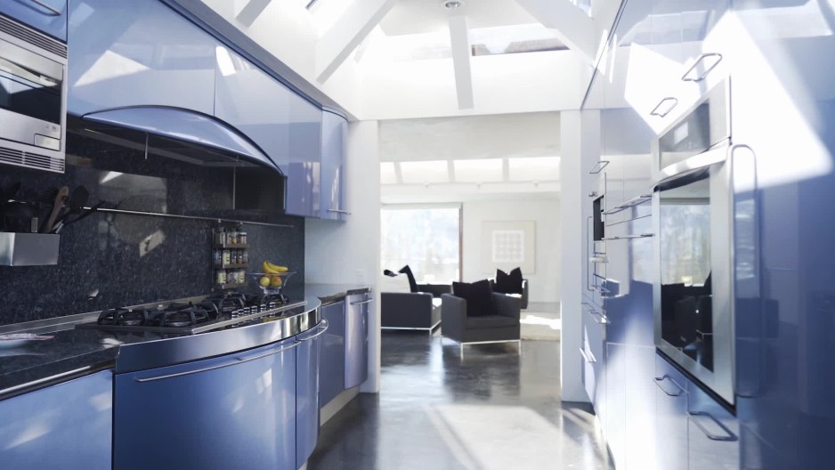 Stunning blue glossy narrow kitchen in modern home with sun shining