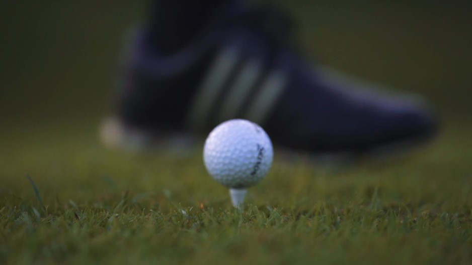 Golfer putting golf ball on tee slow motion ClipStock