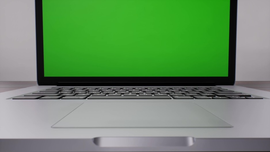 Tilt up towards laptop computer displaying green screen ClipStock