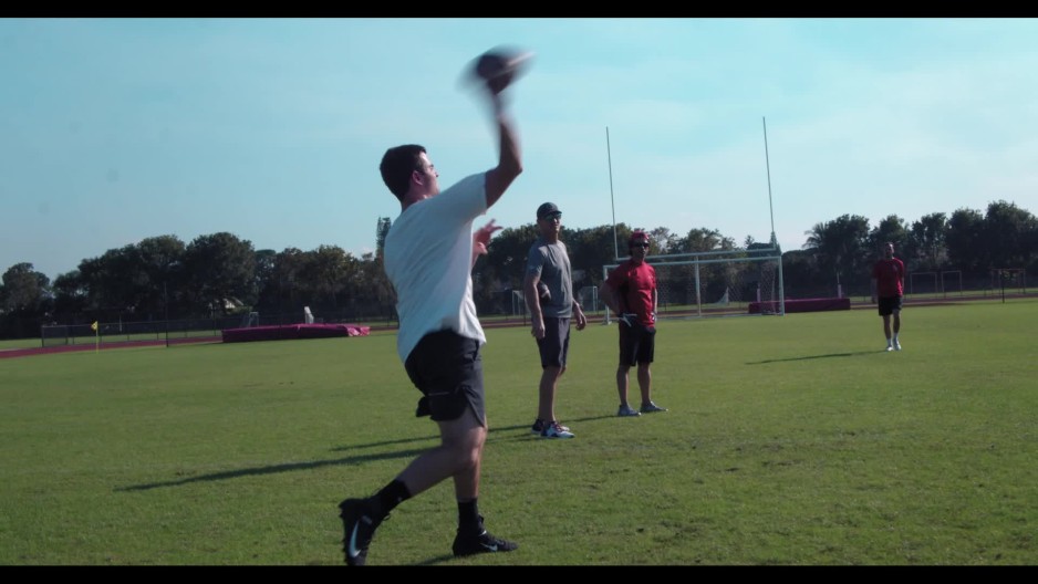 college football quarterback on practice field throws pass to outside