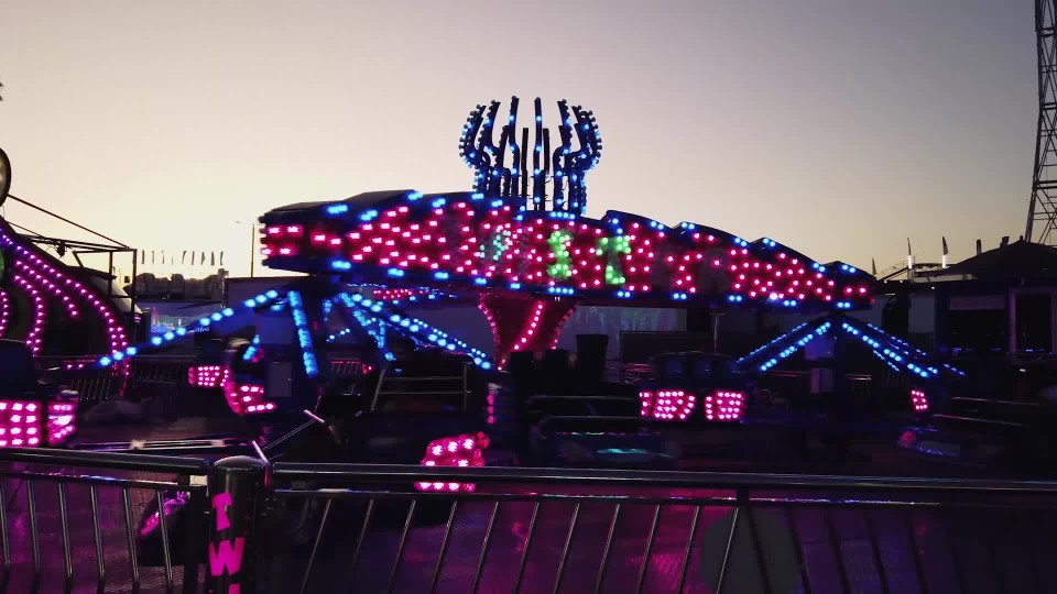 Colorful Spinning Scrambler Amusement Park Ride At Fair At Dusk Clipstock