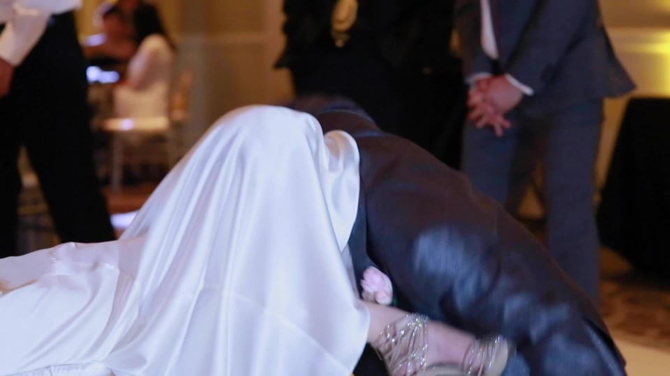 Groom taking off garter belt from bride | ClipStock