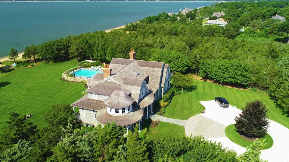 Luxurious mansion with a pool and long stone driveway on the coast of
