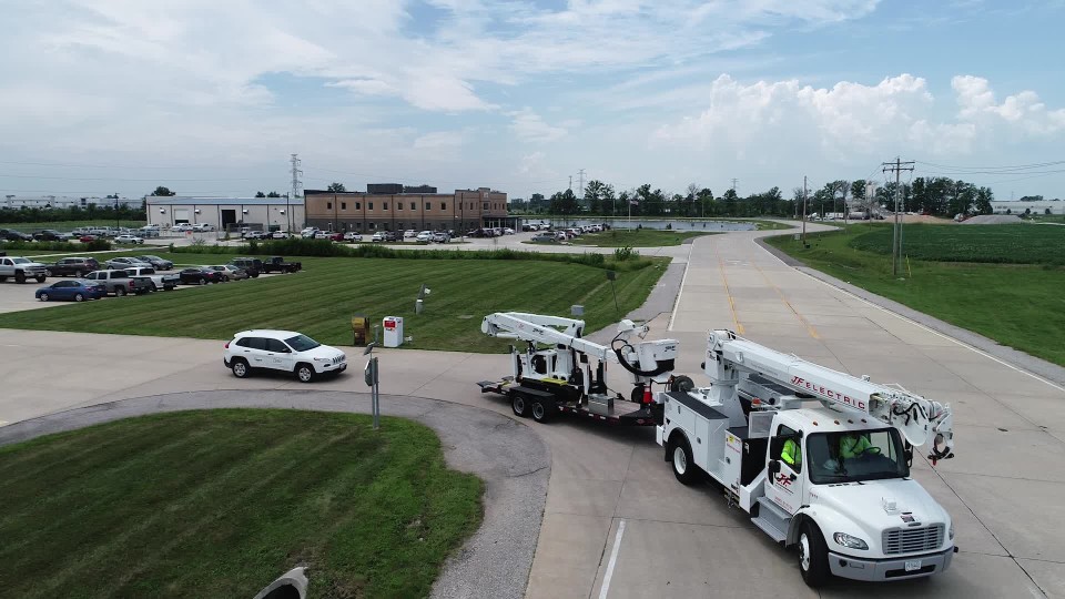 Aerial of cargo trucks driving onto road from lot | ClipStock