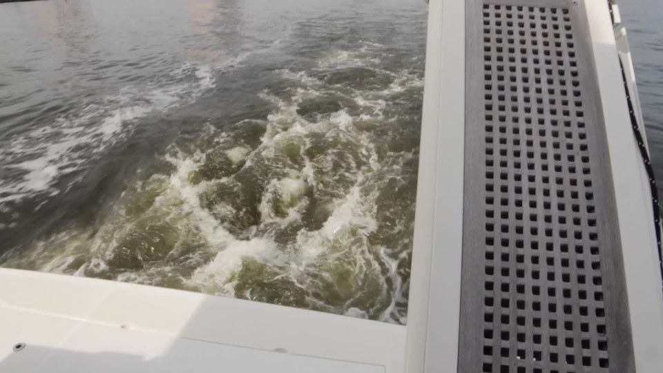 Guy backing boat off trailer into the water at the ramp ClipStock