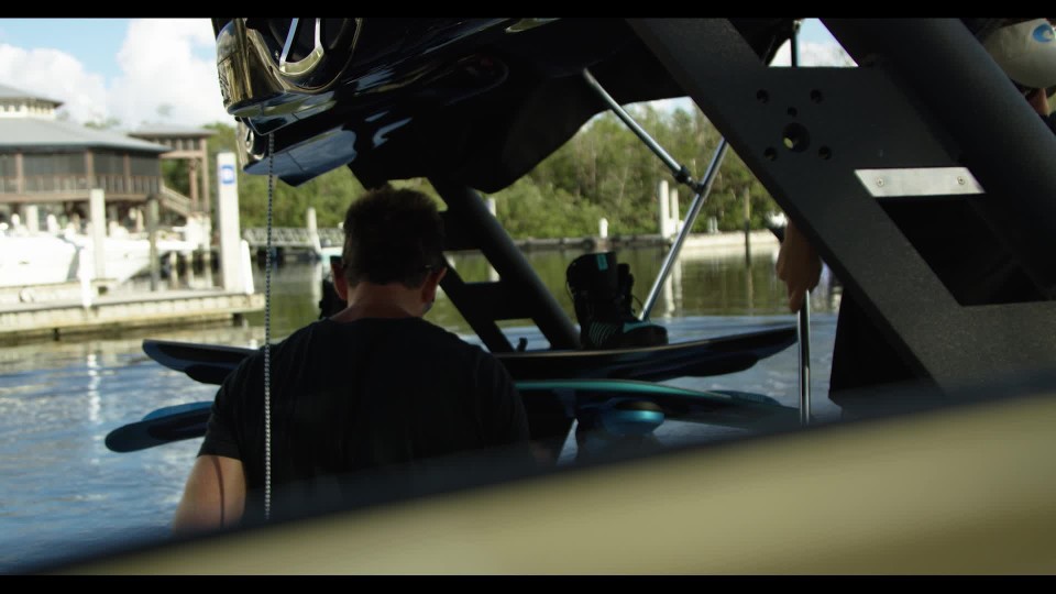 Guy backing boat off trailer into the water at the ramp ClipStock
