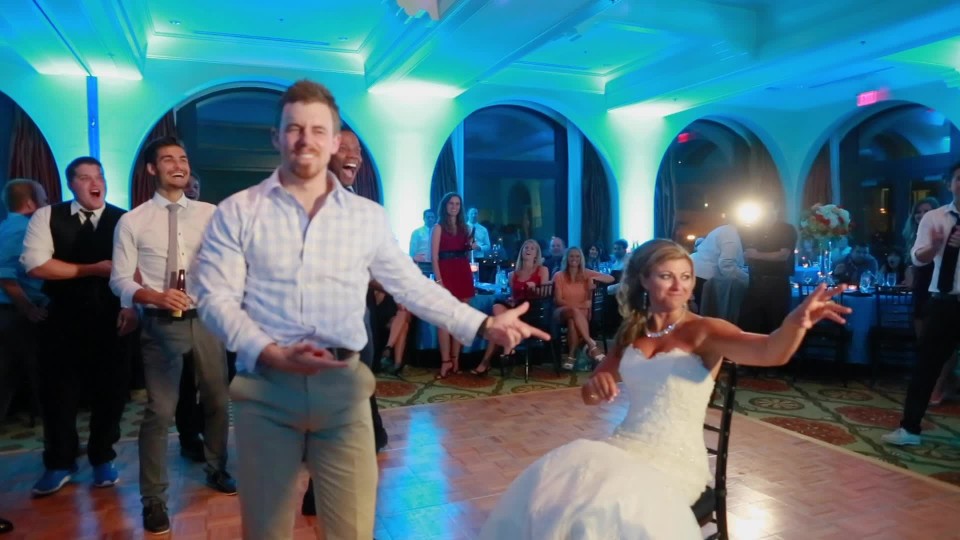 Rack focus of groom preparing garter belt toss in wedding reception |  ClipStock