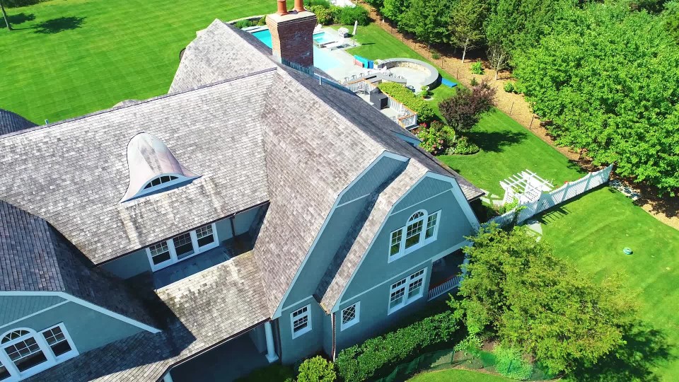 Luxurious mansion with a pool and long stone driveway on the coast of