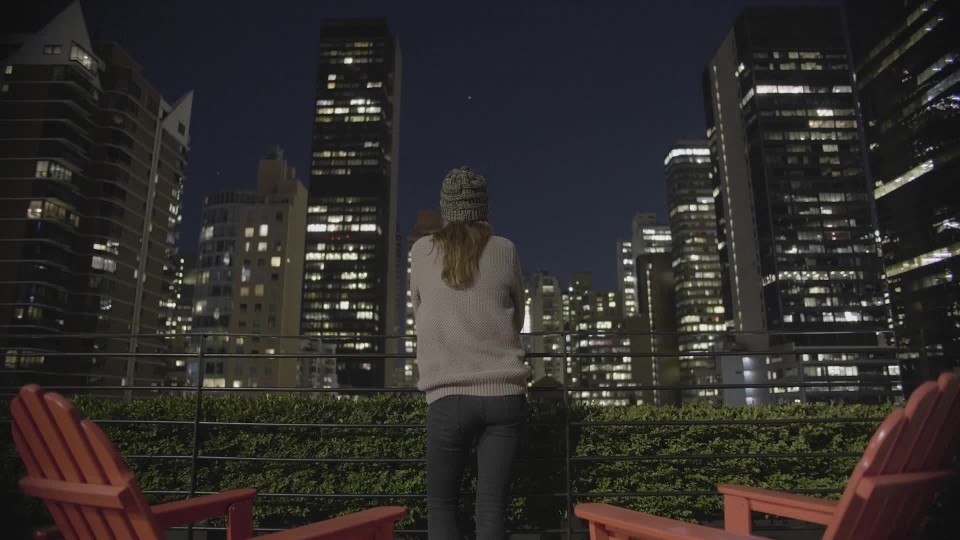 Young Woman Standing On A Roof Balcony In New York City Looking At The Beautiful View At Night Clipstock