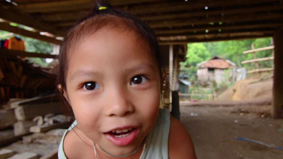 Young girl chewing bubble gum blowing bubble in patio of home | ClipStock