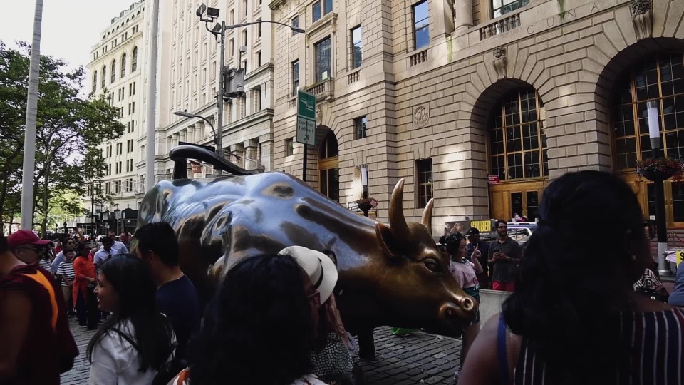 Tourist crowd in front of Charging Bull statue outside New York Stock