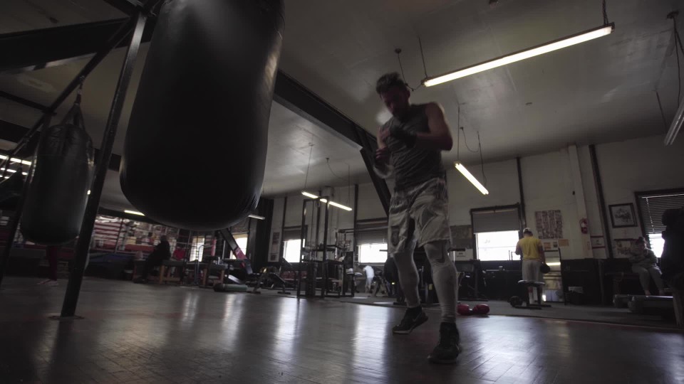 Man hitting punching bag without gloves 5 ClipStock